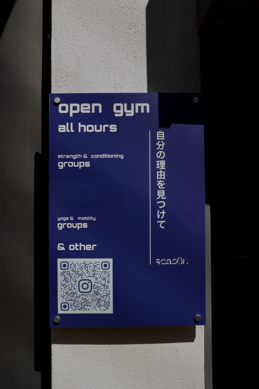 Η μπλε αφίσα του Reason στον τοίχο: Open Gym, όλες τις ώρες, ομαδικά Strength & Conditioning